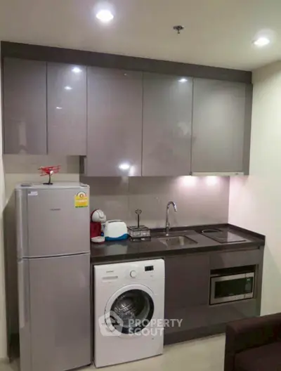 Modern compact kitchen with appliances including washing machine and fridge