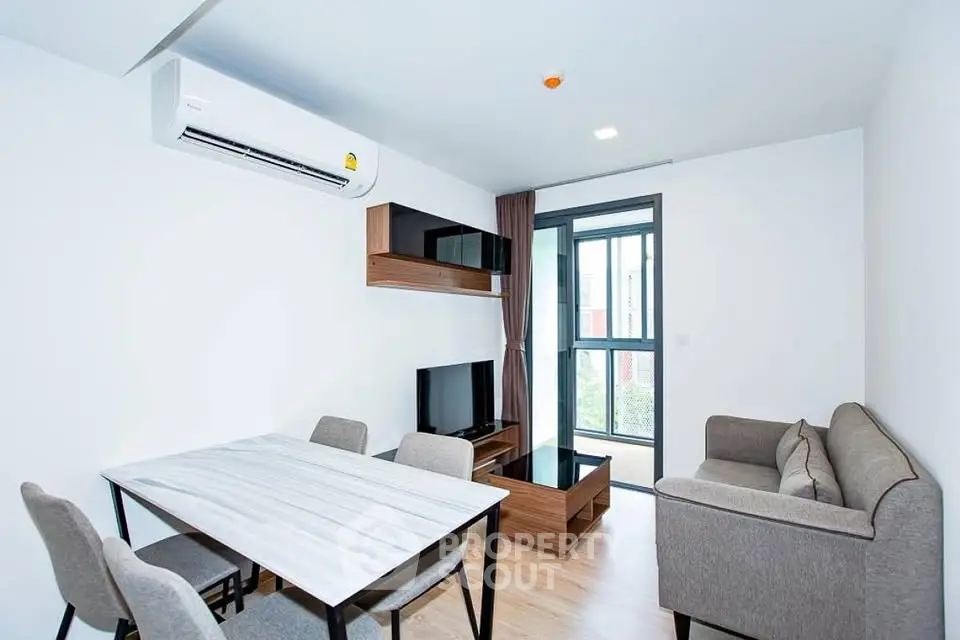 Modern living room with sleek furniture and large window in a stylish apartment.