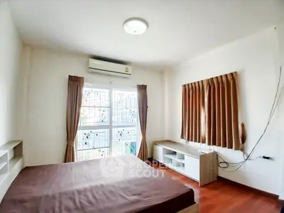 Cozy bedroom with air conditioning and wooden flooring, perfect for relaxation.