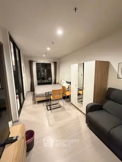 Modern studio apartment with sleek design and cozy furnishings, featuring a comfortable bed and stylish decor.