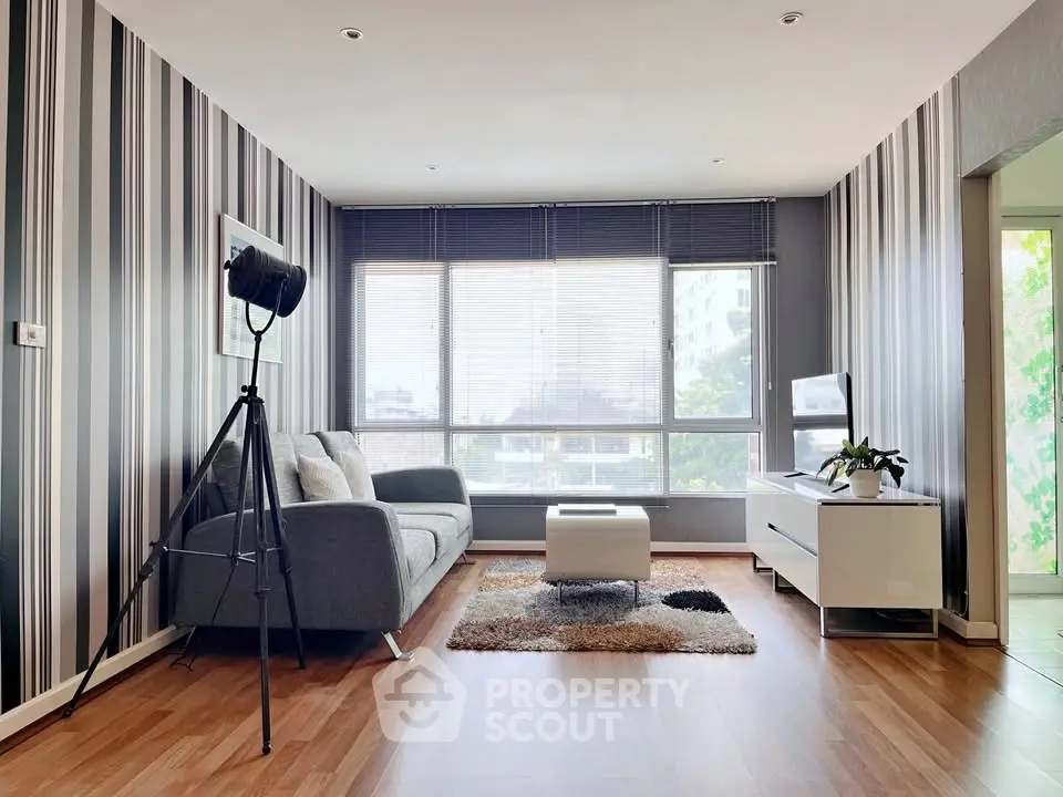 Modern living room with stylish decor and large windows offering natural light.