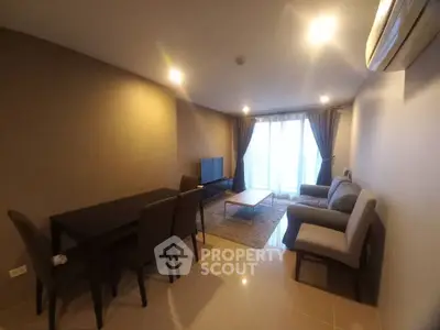 Spacious living room with modern furniture and natural light from large windows.