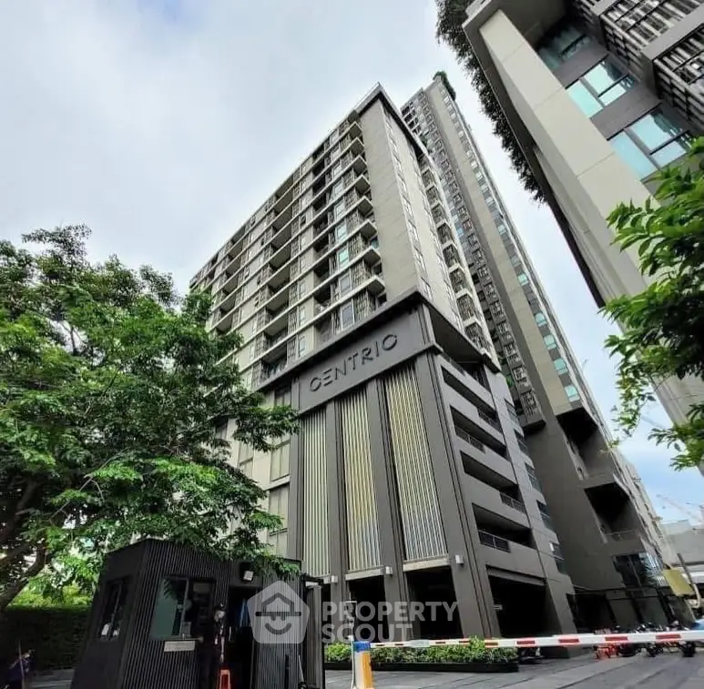Modern high-rise building with sleek design and lush greenery, perfect for urban living.