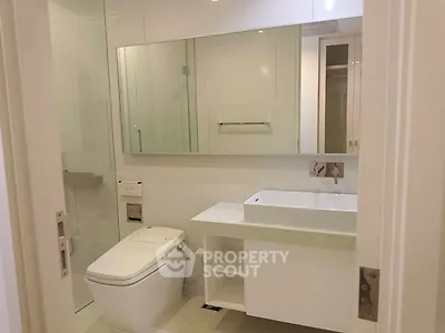 Modern bathroom with sleek fixtures and large mirror in a contemporary home.