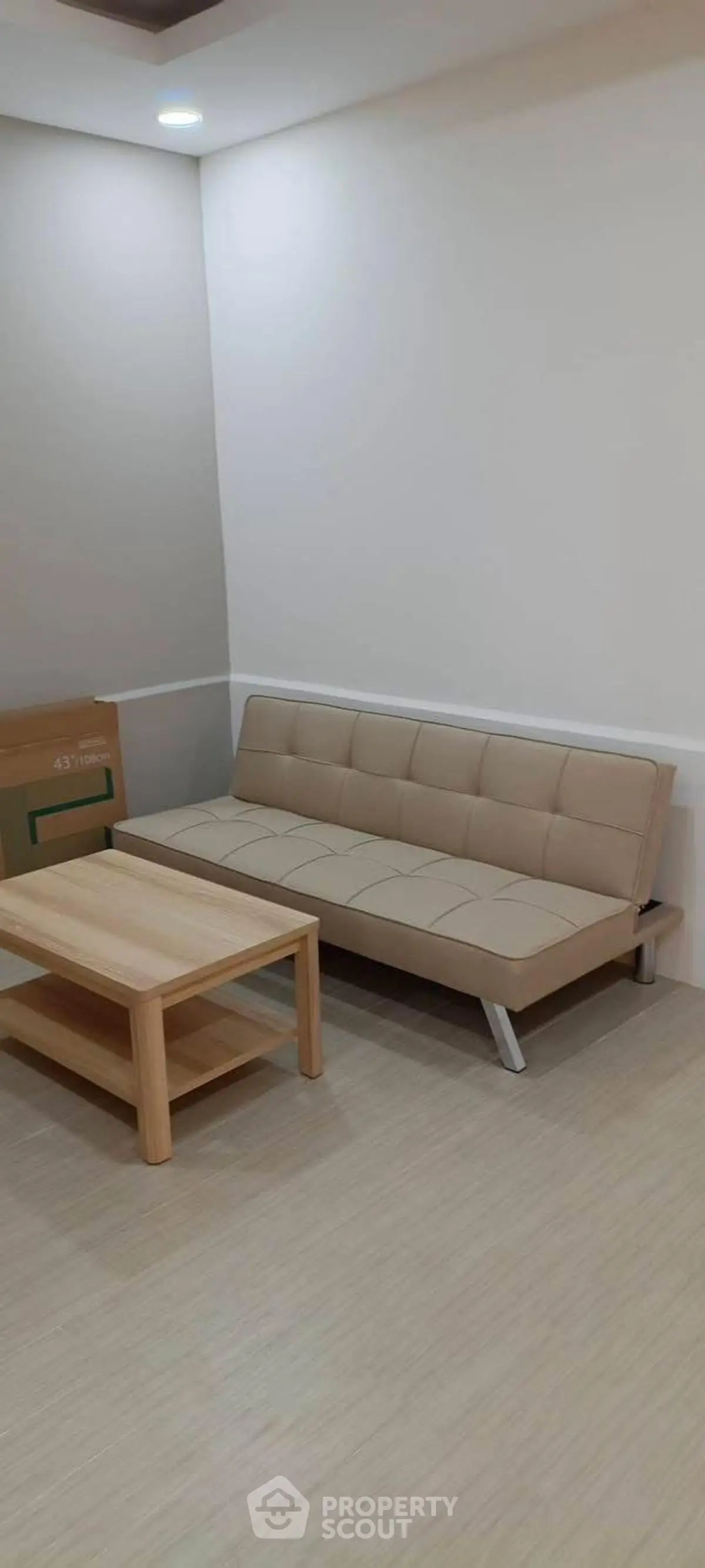 Modern living room with beige sofa and wooden coffee table in minimalist design.