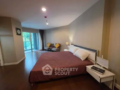 Spacious bedroom with modern decor and balcony view in a luxury apartment.