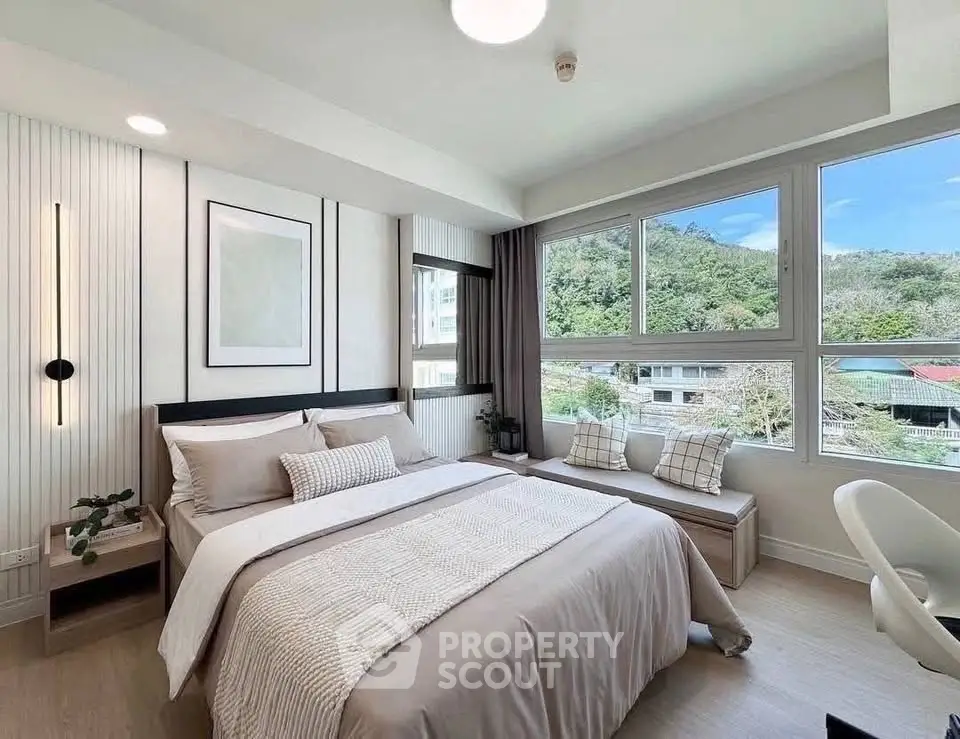 Modern bedroom with large windows and scenic view, featuring cozy decor and natural light.