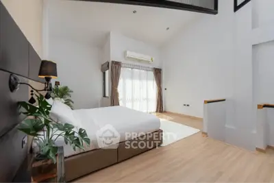 Spacious modern bedroom with high ceiling and natural light