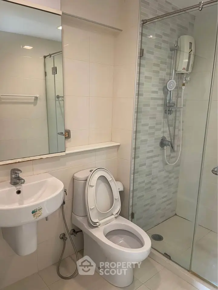 Modern bathroom with glass shower and sleek fixtures in a contemporary apartment.