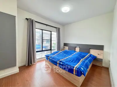 Spacious bedroom with modern decor and large window for natural light