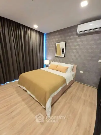 Modern bedroom with stylish decor and air conditioning, featuring cozy lighting and elegant flooring.