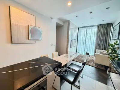 Modern open-layout living room with stylish decor and large windows offering natural light.