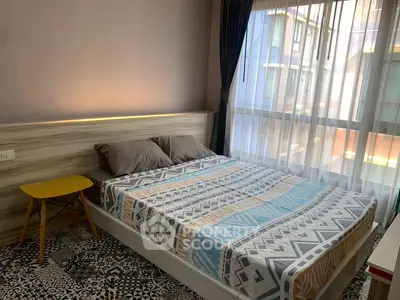 Cozy bedroom with modern decor and large window offering natural light