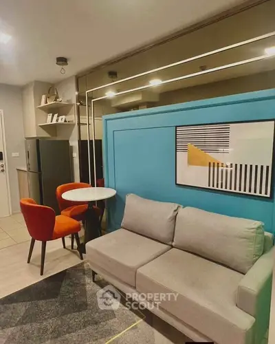 Modern living room with stylish decor, vibrant orange chairs, and sleek gray sofa in a cozy apartment.