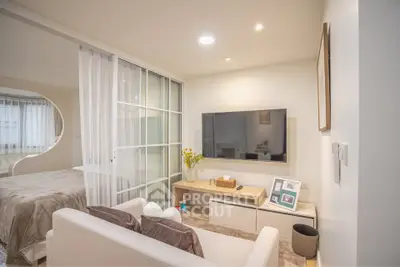 Modern living room with sliding glass doors and wall-mounted TV in cozy apartment