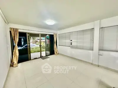 Spacious living room with large windows and sliding glass doors leading to garden.