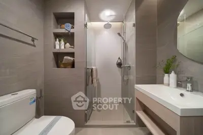 Modern bathroom with glass shower, sleek vanity, and built-in shelving for a stylish and functional design.