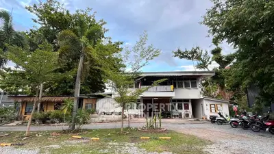 Charming two-story house with lush greenery and ample parking space, perfect for serene living.