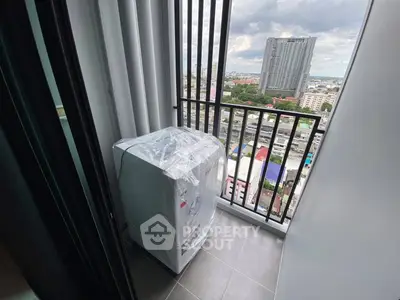 High-rise balcony with city view and washing machine, perfect for urban living.