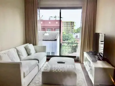 Cozy living room with large window offering a city view, featuring a comfortable sofa and modern TV setup.