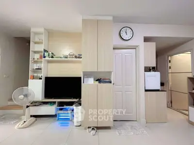 Modern living room with sleek storage and entertainment center, featuring minimalist design and neutral tones.