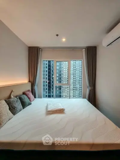 Modern bedroom with large window and city view in high-rise apartment