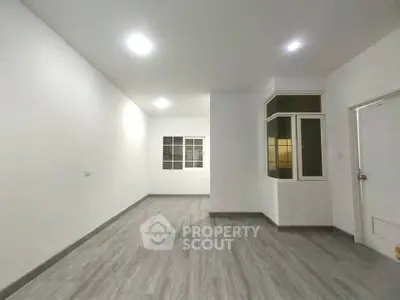 Spacious empty room with modern flooring and bright lighting, ideal for customization.