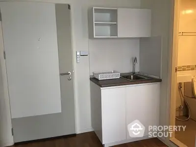 Compact kitchenette with modern sink and storage in cozy apartment