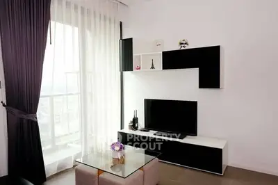 Modern living room with sleek black and white decor and large window view.