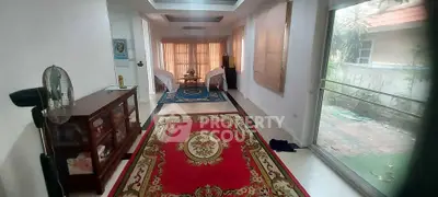 Spacious living room with elegant rugs and large windows overlooking garden