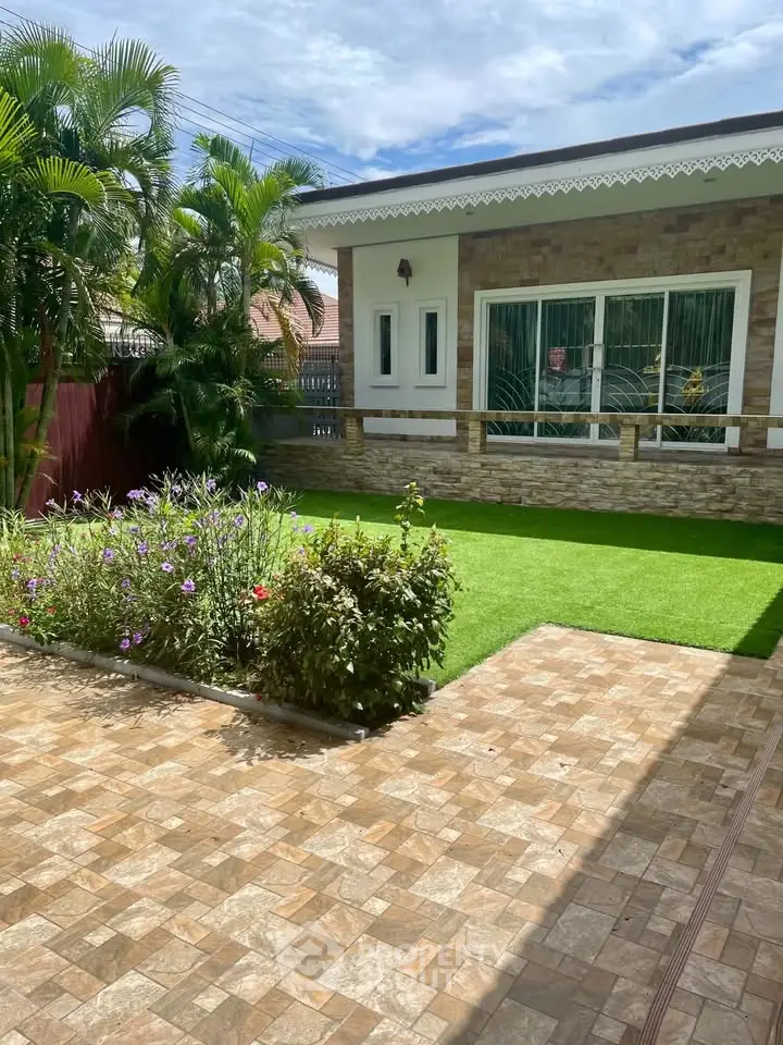 Charming single-story home with lush garden and paved walkway, perfect for serene living.