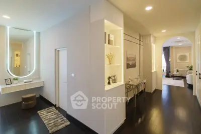 Elegant hallway leading to a spacious living room with modern decor and ambient lighting.