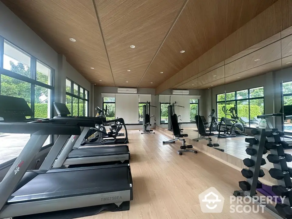 Spacious modern gym with large mirrors and state-of-the-art equipment in a luxury property.