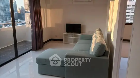 Modern living room with large sofa and balcony view in urban apartment