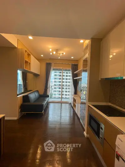 Modern kitchen with open layout and balcony view in high-rise apartment.