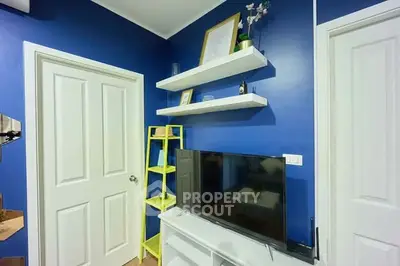 Modern living room with blue walls, white doors, and a sleek TV setup.