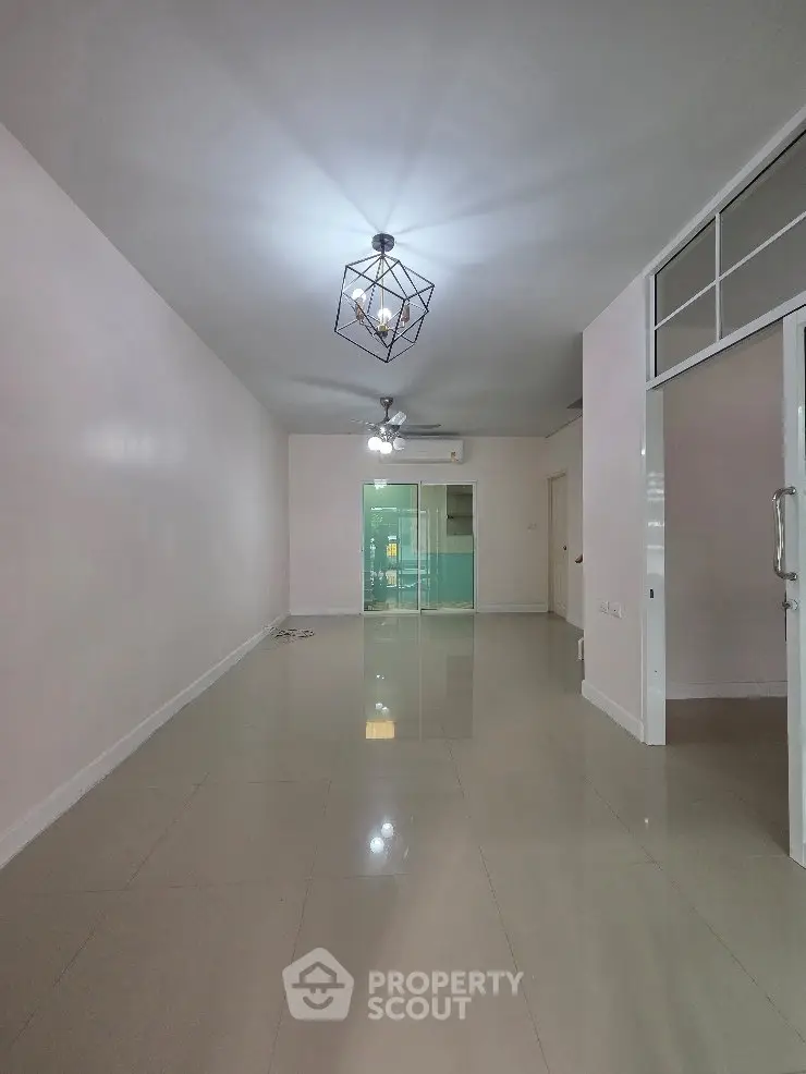 Spacious modern living room with sleek lighting and glossy tiled floors