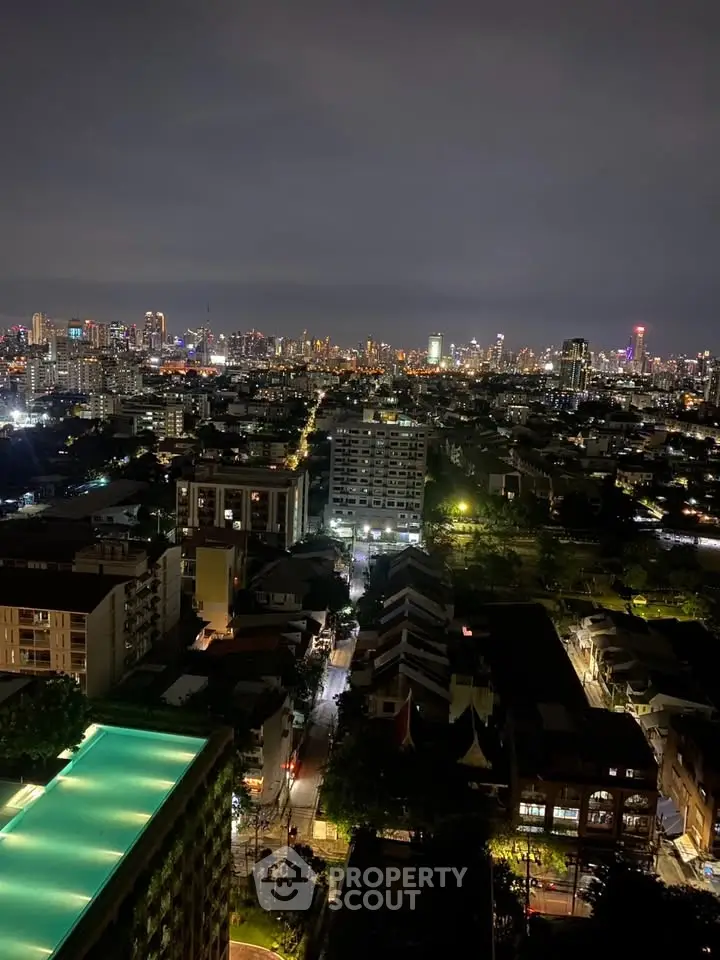 Stunning cityscape view from high-rise building at night with vibrant city lights.