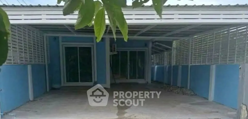 Charming single-story home with covered carport and modern blue exterior.