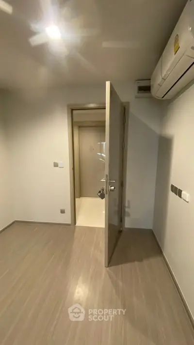 Modern minimalist room with wooden flooring and air conditioning unit