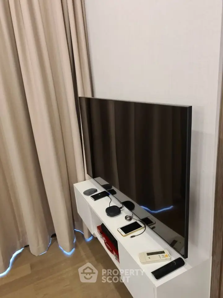 Modern living room with sleek TV setup and elegant curtains