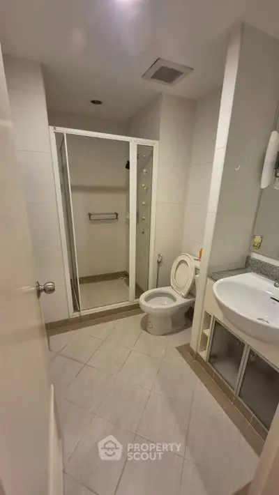 Modern bathroom with glass shower and sleek fixtures in a contemporary apartment.