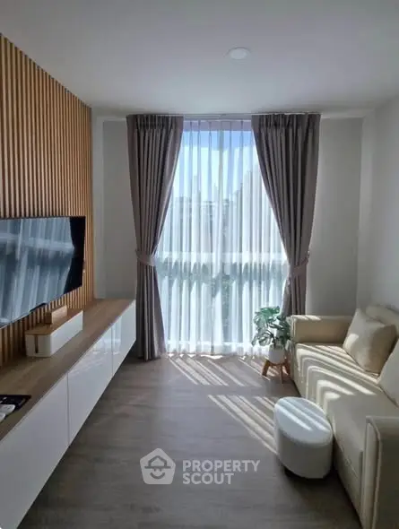 Modern living room with sleek TV setup and elegant curtains