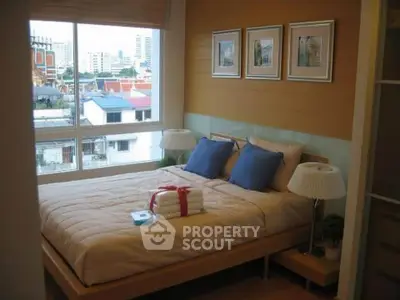 Cozy bedroom with city view, featuring a comfortable bed and stylish decor.