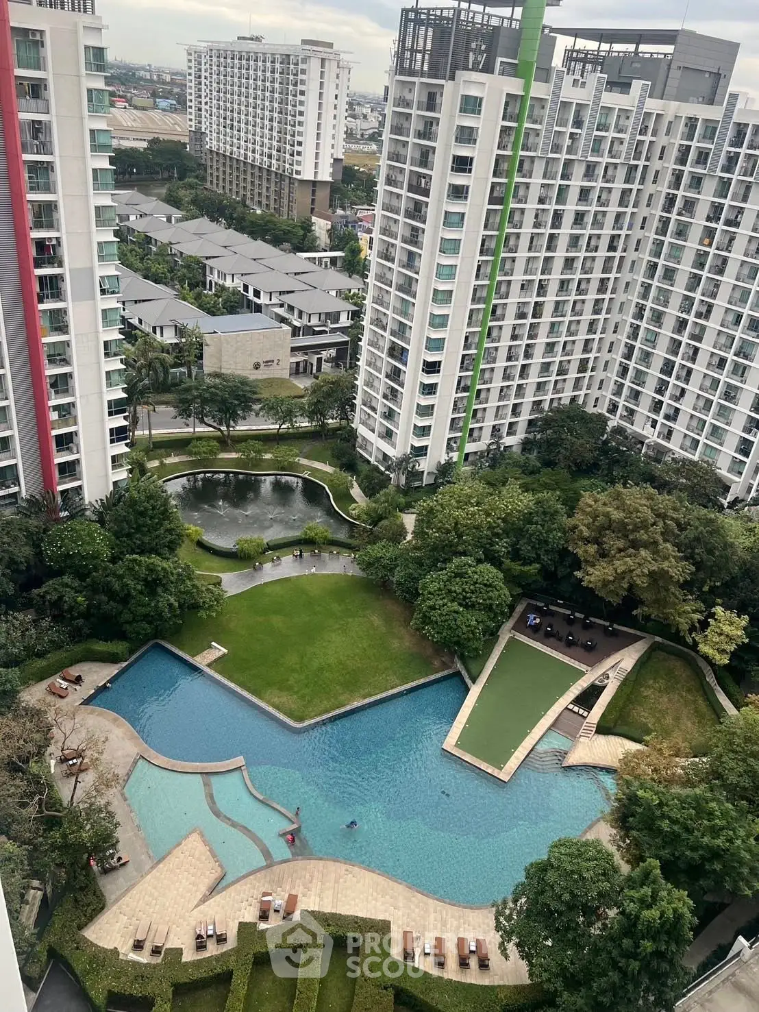 Stunning aerial view of modern residential complex with lush gardens and inviting swimming pool.