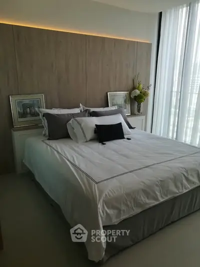 Luxurious bedroom with elegant decor and large windows offering natural light.