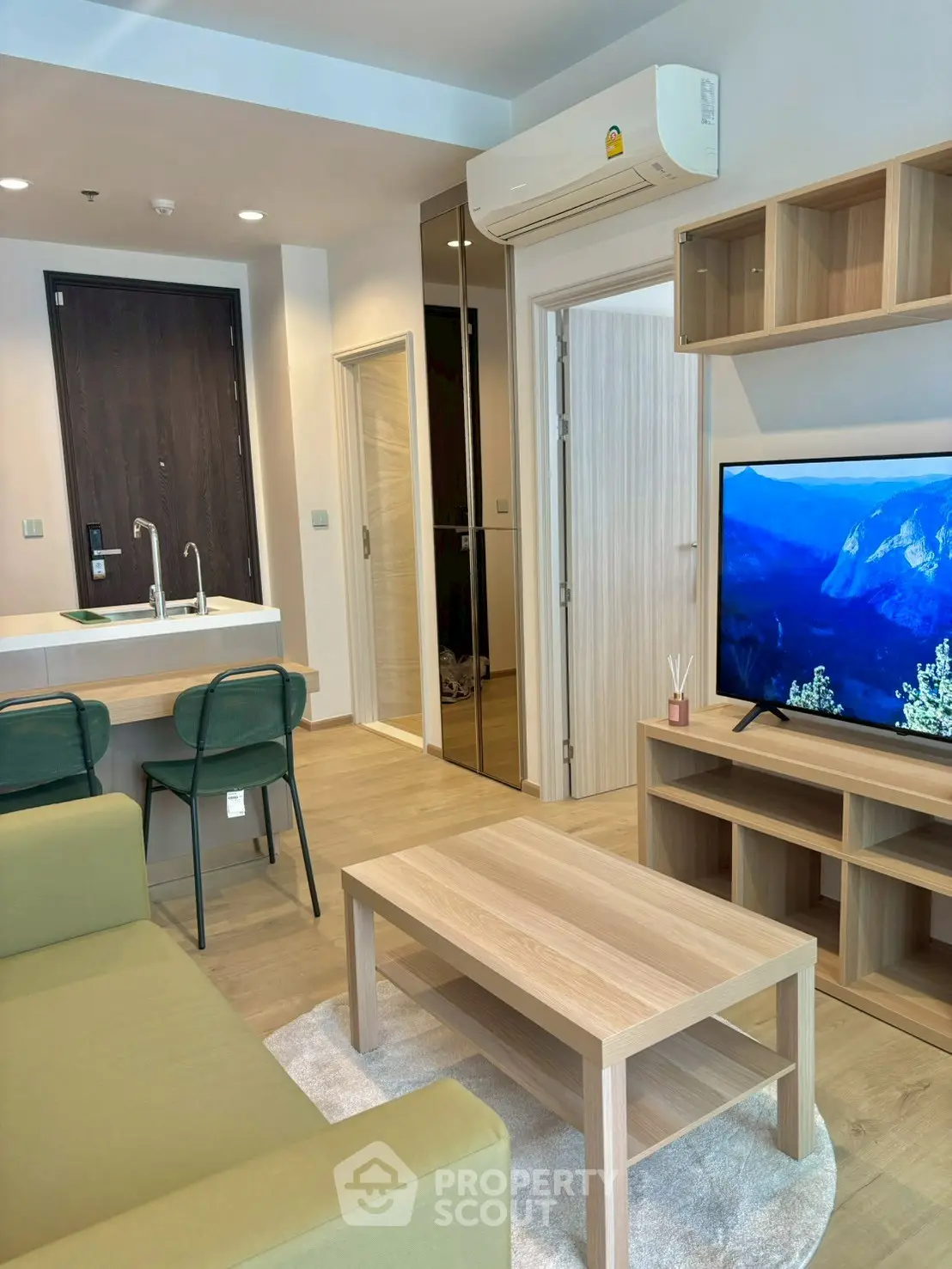 Modern living room with sleek furniture and open kitchen layout in a stylish apartment.