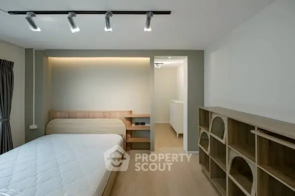 Modern minimalist bedroom with wooden furniture and ambient lighting.