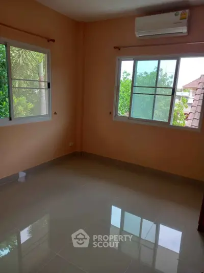 Bright empty room with large windows and air conditioning, perfect for customization.