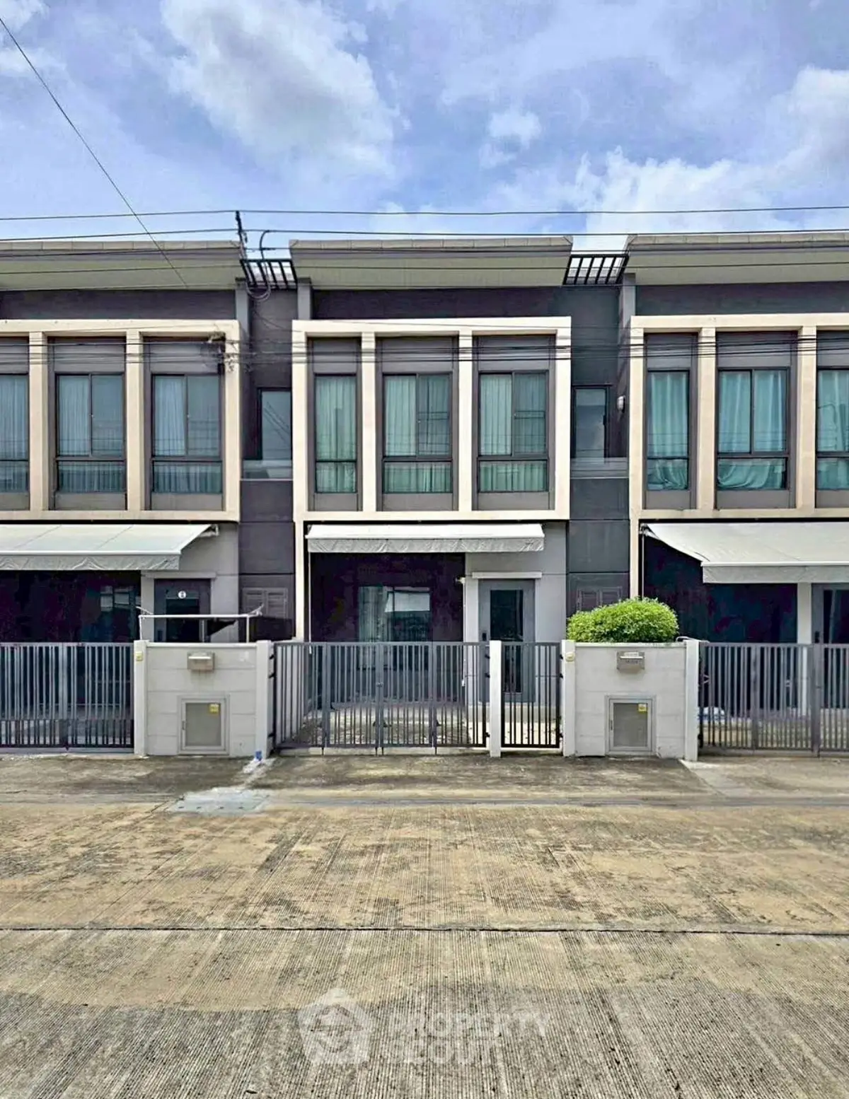 Modern townhouse exterior with sleek design and gated entrance